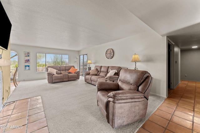 tiled living room with a fireplace, a textured ceiling, and carpet flooring