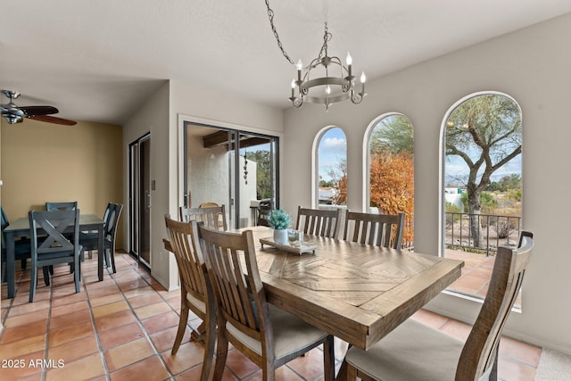 dining space with ceiling fan with notable chandelier and light tile patterned floors