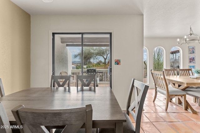 dining area featuring light tile patterned floors and a notable chandelier