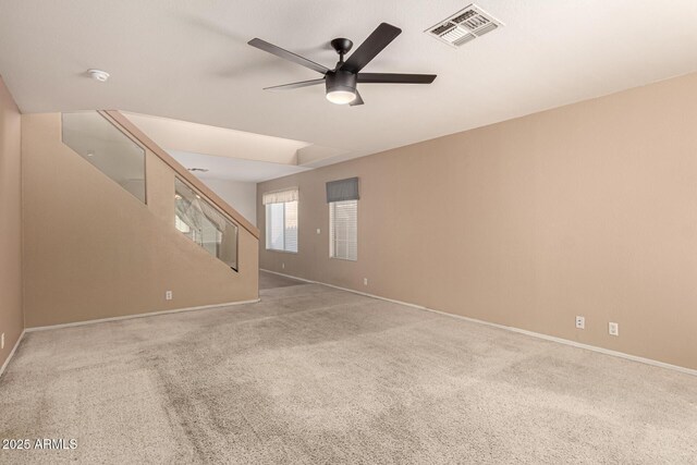 spare room with baseboards, carpet, visible vents, and a ceiling fan