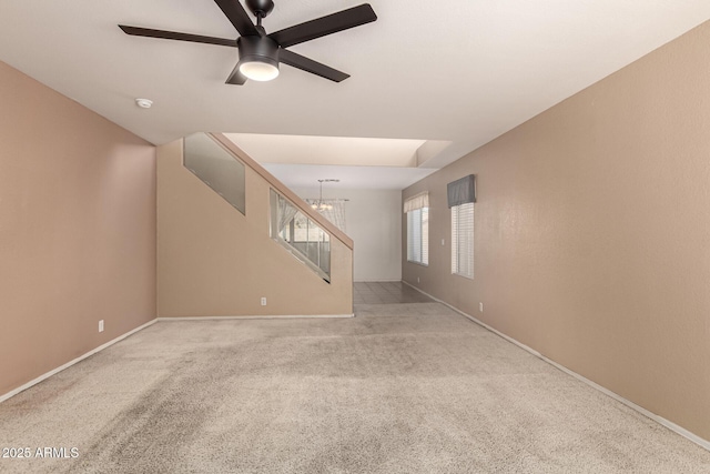 unfurnished room with light carpet and ceiling fan with notable chandelier