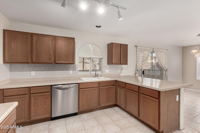 kitchen with a wealth of natural light, a sink, a peninsula, and stainless steel dishwasher