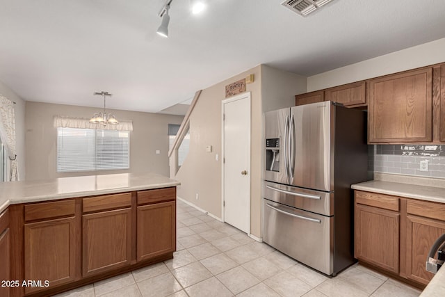 kitchen with brown cabinets, visible vents, backsplash, and stainless steel fridge with ice dispenser