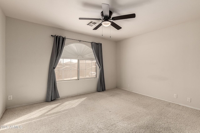 empty room with carpet flooring, visible vents, and a ceiling fan