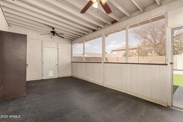 unfurnished sunroom featuring ceiling fan and beamed ceiling