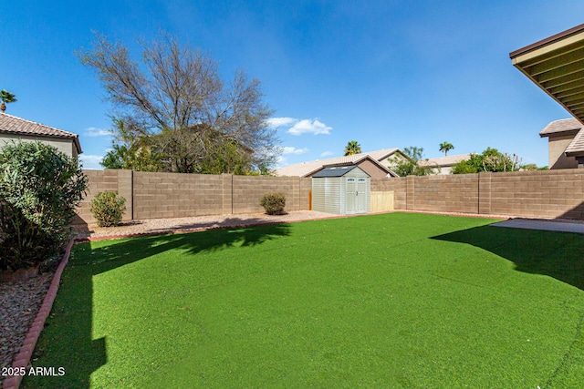 view of yard featuring a shed, an outdoor structure, and a fenced backyard