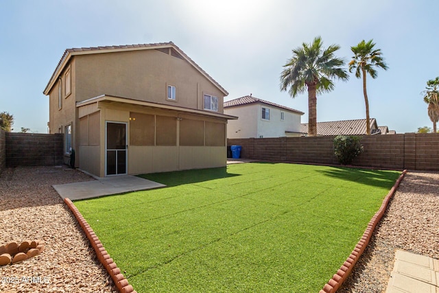 back of house with a yard, a fenced backyard, and stucco siding