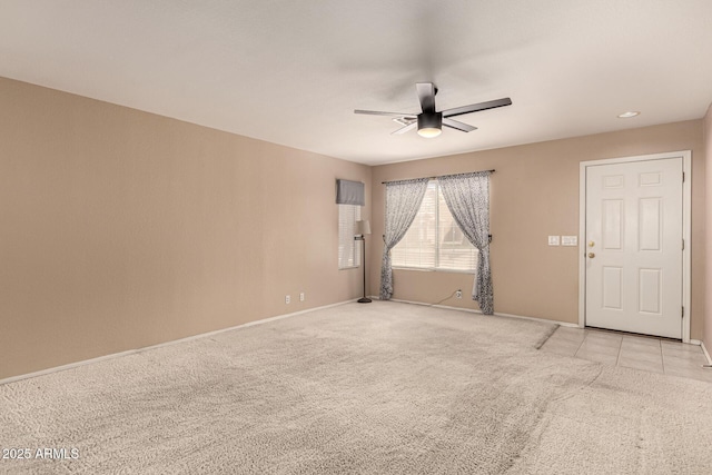 unfurnished room with ceiling fan, baseboards, and light colored carpet