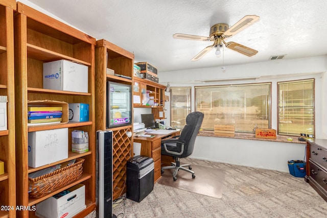 office space featuring ceiling fan, light carpet, and a textured ceiling