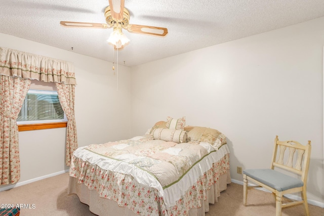 carpeted bedroom featuring ceiling fan and a textured ceiling