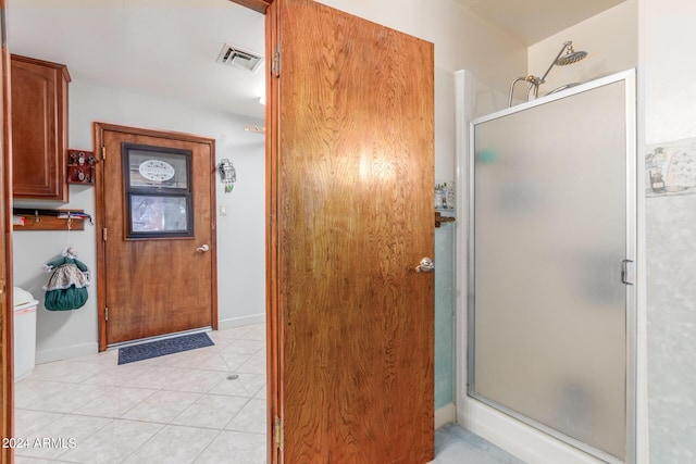 bathroom with an enclosed shower and tile patterned floors