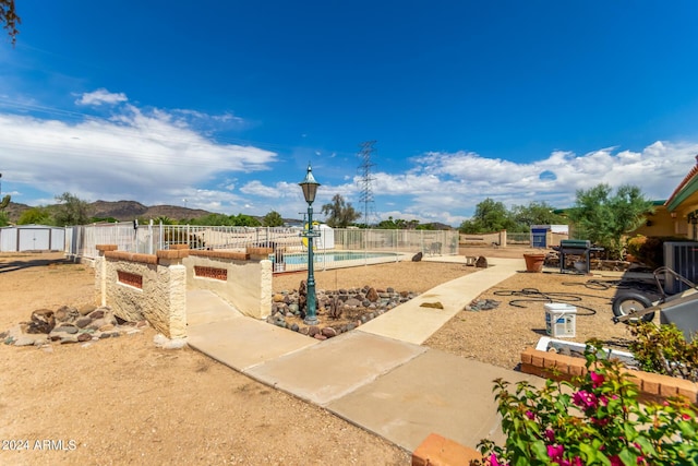 exterior space featuring a fenced in pool, a mountain view, and central AC