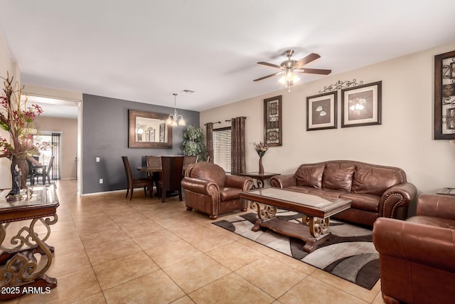 living area with light tile patterned floors, visible vents, baseboards, and a ceiling fan