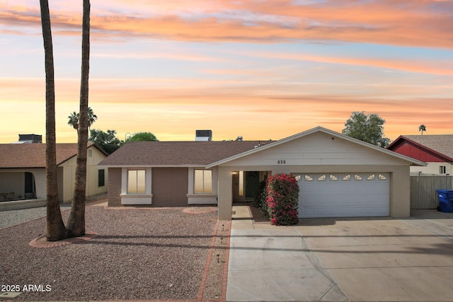 single story home featuring an attached garage, driveway, and brick siding