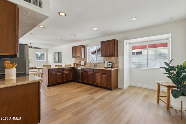 kitchen featuring a sink, plenty of natural light, stainless steel appliances, and light wood-style flooring