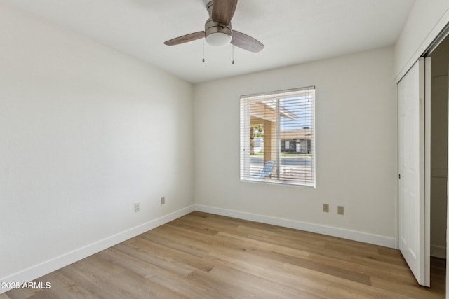 unfurnished bedroom with a closet, baseboards, and light wood-style floors