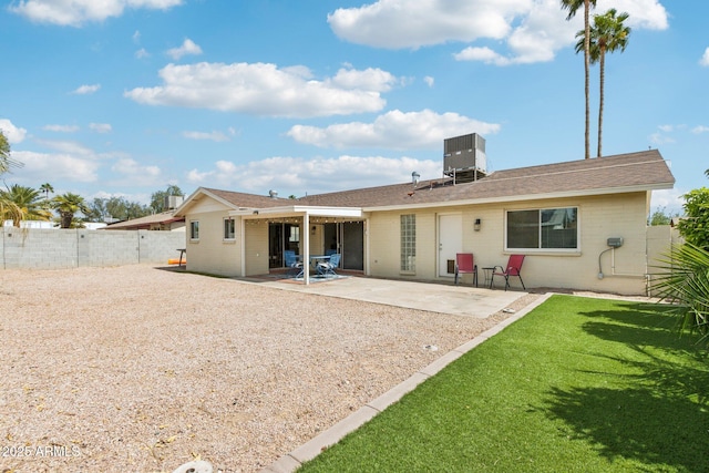 back of house with cooling unit, a patio, a fenced backyard, brick siding, and a yard