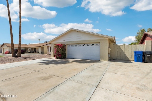 single story home featuring concrete driveway, fence, and a garage