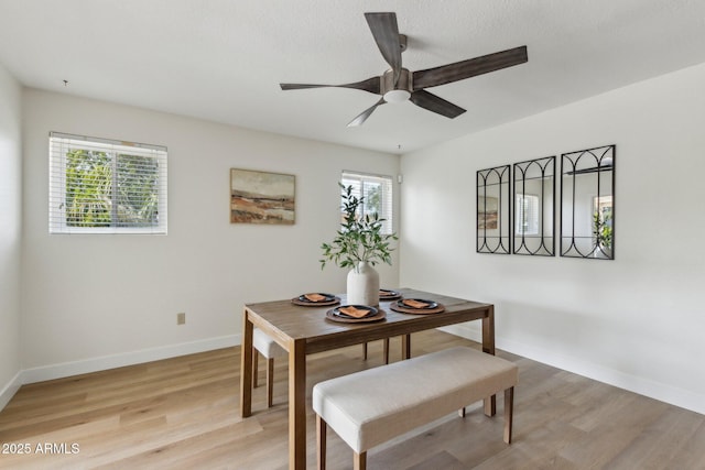 dining room featuring a ceiling fan, baseboards, and light wood-type flooring