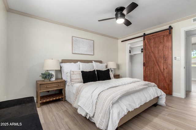 3050 E Cholla St E, Phoenix, AZ 85028 - bedroom featuring light wood finished floors, crown molding, a closet, a barn door, and ceiling fan