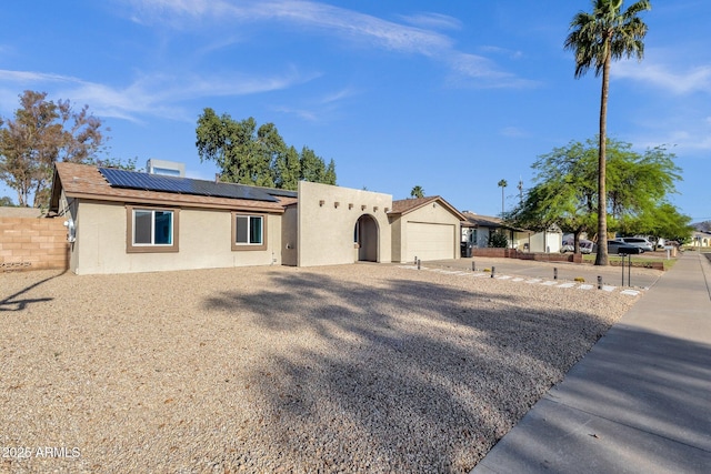 14215 N 36th Way, Phoenix, AZ 85032 - view of front of home with stucco siding, roof mounted solar panels, a garage, and driveway