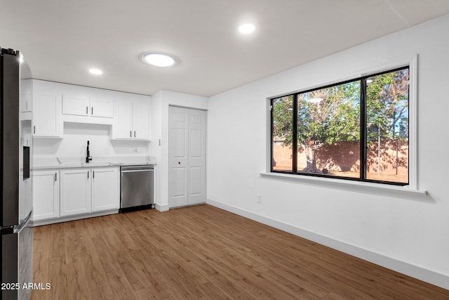 14215 N 36th Way, Phoenix, AZ 85032 - kitchen with appliances with stainless steel finishes, a sink, baseboards, light wood-style flooring, and white cabinetry