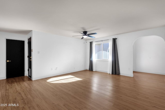 14215 N 36th Way, Phoenix, AZ 85032 - spare room with arched walkways, ceiling fan, wood finished floors, and baseboards