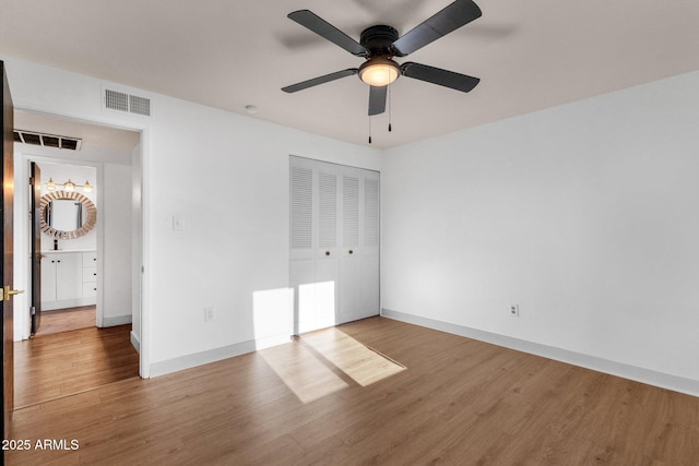 14215 N 36th Way, Phoenix, AZ 85032 - unfurnished bedroom featuring wood finished floors, a closet, baseboards, and a ceiling fan
