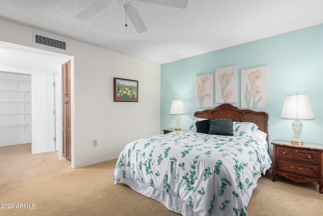 carpeted bedroom featuring a textured ceiling, ceiling fan, and a closet