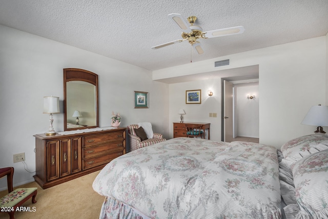 bedroom with ceiling fan, light carpet, and a textured ceiling