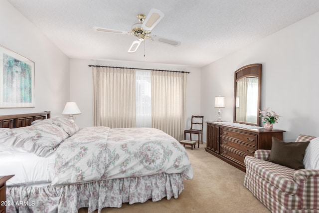 carpeted bedroom featuring multiple windows, a textured ceiling, and ceiling fan