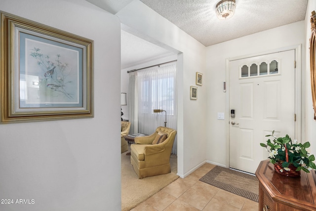 foyer featuring light tile patterned flooring and a textured ceiling