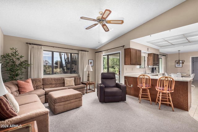 living room with light colored carpet, sink, lofted ceiling, ceiling fan, and a textured ceiling