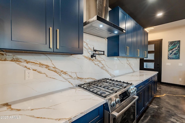 kitchen with wall chimney exhaust hood, stainless steel gas stove, blue cabinetry, tasteful backsplash, and light stone countertops