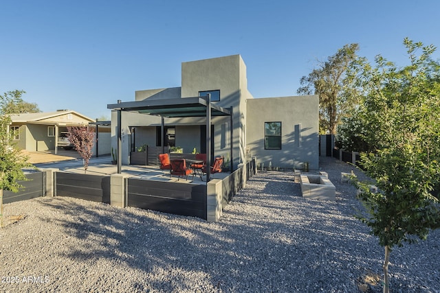 rear view of property with stucco siding and a patio area