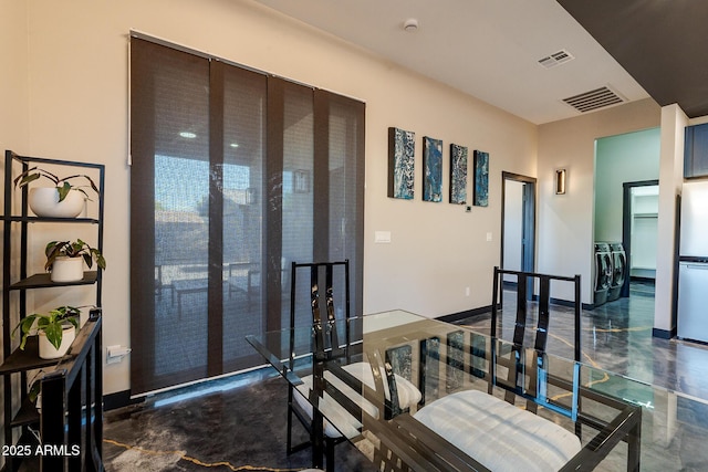 corridor featuring separate washer and dryer and concrete floors