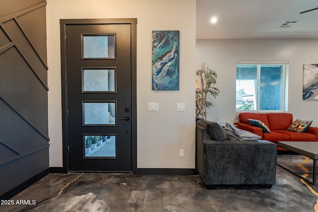 entrance foyer featuring concrete floors, baseboards, and stairway