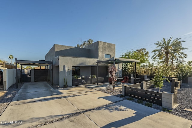 view of front facade featuring a gate, driveway, and stucco siding
