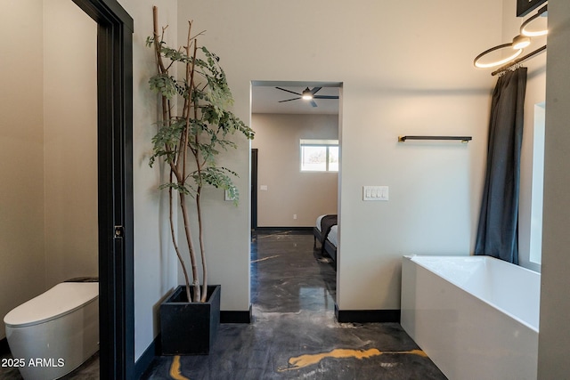bathroom with baseboards, a bath, finished concrete flooring, and toilet