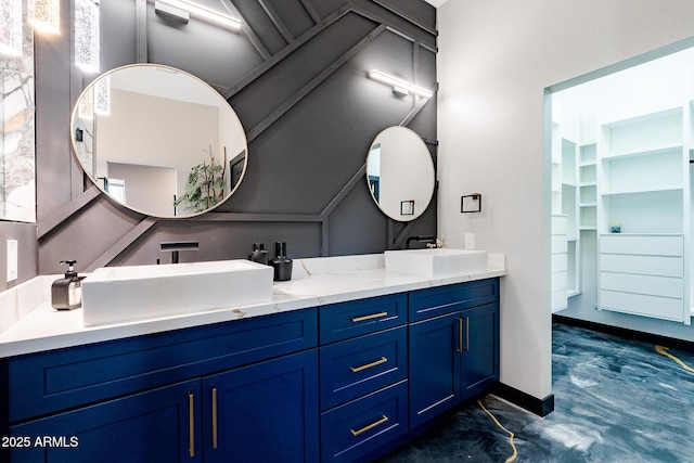 bathroom with double vanity and baseboards