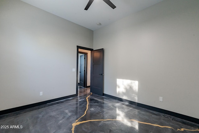 spare room with concrete floors, ceiling fan, and baseboards