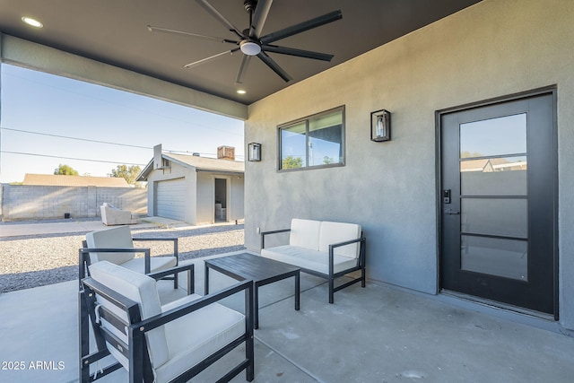 view of patio / terrace with ceiling fan, fence, an outbuilding, and an outdoor hangout area