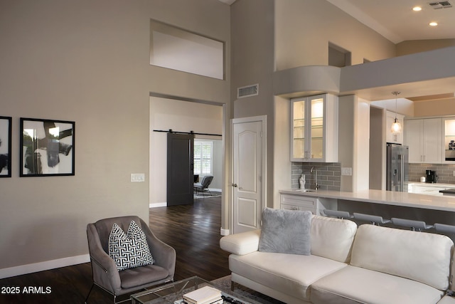 14424 N 64th Pl, Scottsdale, AZ 85254 - living area featuring baseboards, dark wood finished floors, recessed lighting, a barn door, and high vaulted ceiling