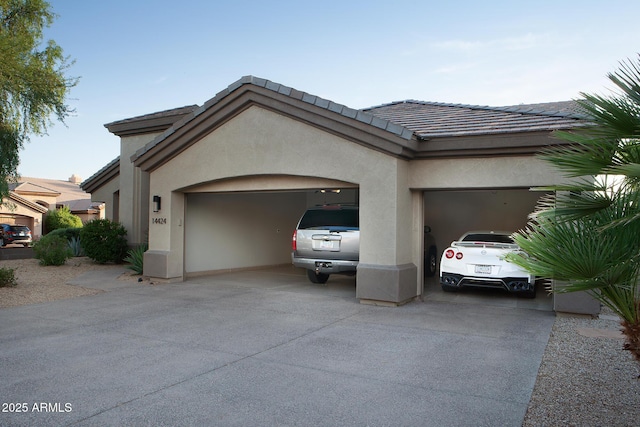 14424 N 64th Pl, Scottsdale, AZ 85254 - view of property exterior featuring driveway, an attached garage, stucco siding, and a tiled roof