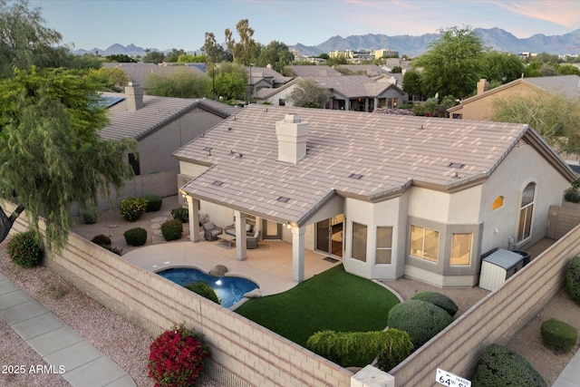 14424 N 64th Pl, Scottsdale, AZ 85254 - back of property at dusk with a fenced backyard, a mountain view, stucco siding, a patio, and a chimney