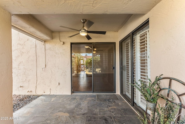 doorway to property with stucco siding and a ceiling fan