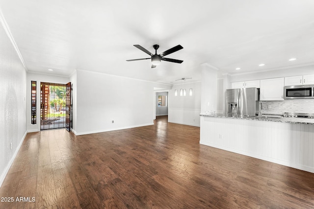 unfurnished living room featuring baseboards, dark wood-style floors, a ceiling fan, and crown molding