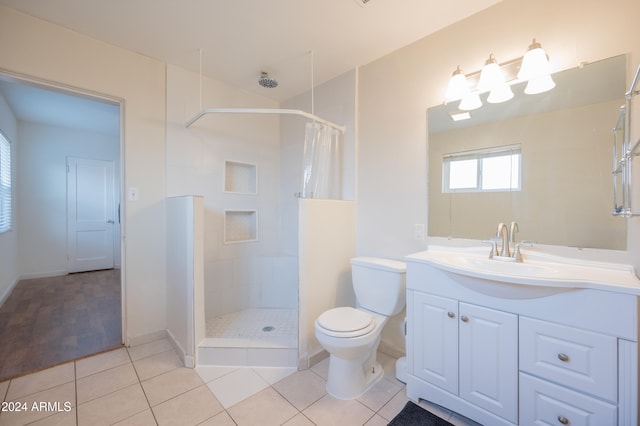 bathroom with curtained shower, tile patterned floors, vanity, and toilet