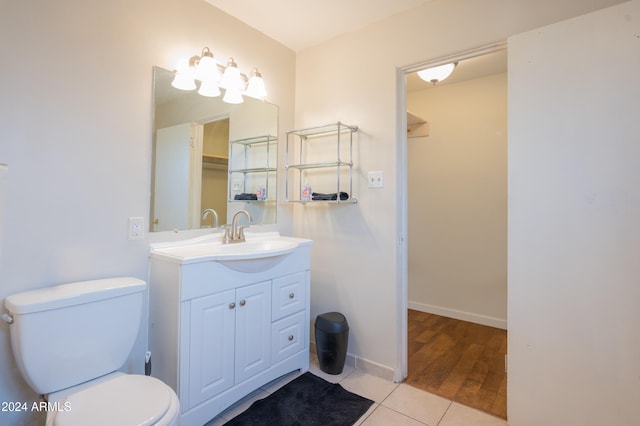 bathroom with toilet, tile patterned floors, and vanity