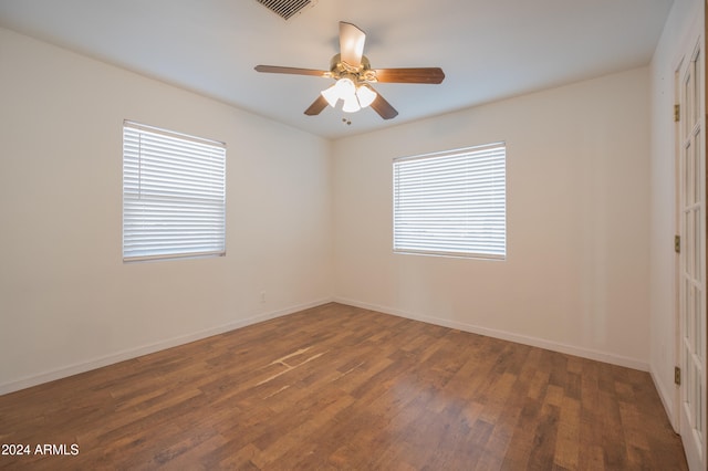 spare room featuring ceiling fan, plenty of natural light, and dark hardwood / wood-style floors